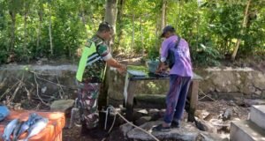 Babinsa Koramil 02/Sukakarya Laksanakan Komsos dengan Pedagang Ikan di Pasar, Sembari Ikut Membantu