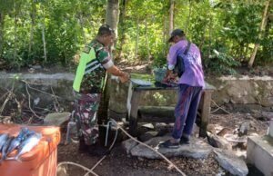 Babinsa Koramil 02/Sukakarya Laksanakan Komsos dengan Pedagang Ikan di Pasar, Sembari Ikut Membantu