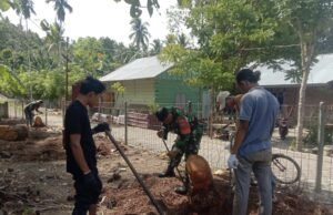 Babinsa Koramil 01/Sukajaya Bersama Bantu Warga Bongkar Akar Kelapa untuk Perluasan Jalan Desa