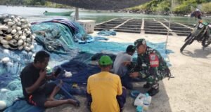 Wujud Kepedulian TNI, Babinsa Bantu Nelayan di Krueng Raya Perbaiki Jaring Ikan