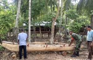 Babinsa Koramil 01/Sukajaya Bantu Warga Bangun Perahu Tradisional untuk Dukung Perekonomian Nelayan