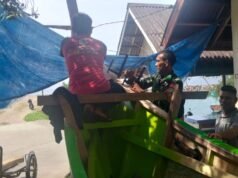 Wujud Kebersamaan, Babinsa Koramil 01/Sukajaya Ikut Andil Perbaiki Perahu Warga