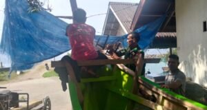 Wujud Kebersamaan, Babinsa Koramil 01/Sukajaya Ikut Andil Perbaiki Perahu Warga