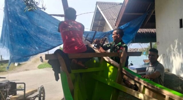 Wujud Kebersamaan, Babinsa Koramil 01/Sukajaya Ikut Andil Perbaiki Perahu Warga