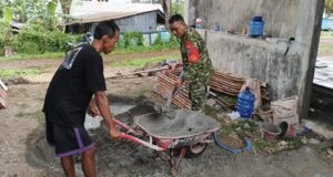 Tak Canggung Kotor, Babinsa Kuta Barat Bantu Warga Aduk Semen Pembangunan KDKMP