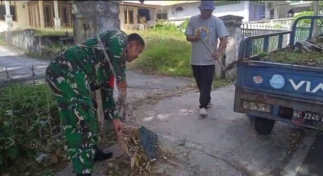 Ciptakan Lingkungan Sehat, Babinsa Koramil 01/Sukajaya dan Warga Bersihkan Sisi Jalan Gampong Ie Meulee