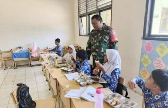 Wujud Dukungan Program Pemerintah, Babinsa Ujong Kareung Pantau Langsung Penyaluran Makanan Bergizi di Sekolah