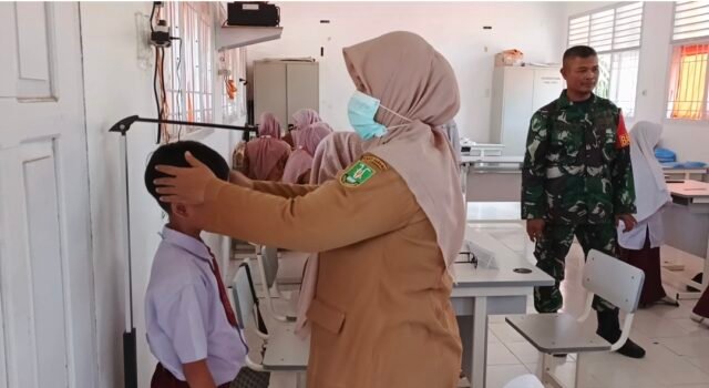 Dukung Kesehatan Pelajar, Babinsa Paya Seunara Dampingi Cek Kesehatan Gratis di SDN 19