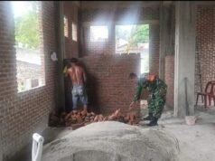 Wujudkan Kemanunggalan TNI-Rakyat, Babinsa Kuta Timu Bantu Pengerjaan Kantor Keuchik